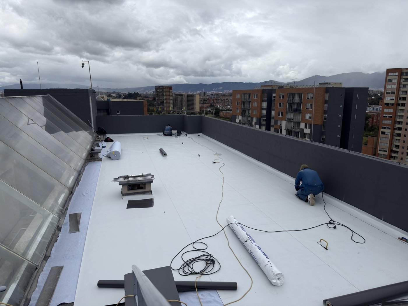 Instalación de membrana impermeabilizante en cubierta con vista de Bogotá