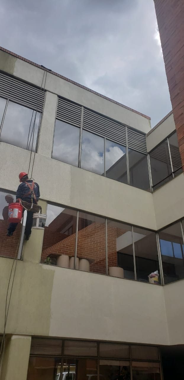 Técnico en descenso sobre fachada de edificio de oficinas